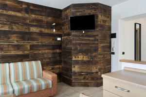 a living room with a wooden wall with a tv at Ride Home 2 in Commezzadura