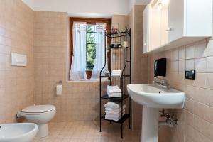 a bathroom with a sink and a toilet and a window at Ride Home 2 in Commezzadura