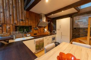 a kitchen with wooden walls and a wooden table at Gite d'Orgeix - Ax-les-Thermes in Orgeix