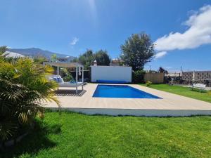a small swimming pool in a yard with a lawn at Casa Deco in San Borondón