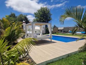 a bed on a wooden deck next to a swimming pool at Casa Deco in San Borondón +8 photos