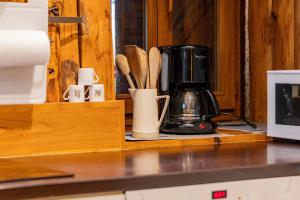 a kitchen counter with a coffee maker and wooden utensils at Gite d'Orgeix - Ax-les-Thermes in Orgeix