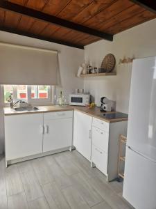a kitchen with white cabinets and a white refrigerator at Casa Deco in San Borondón