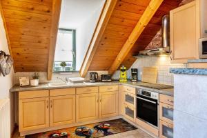 a kitchen with wooden cabinets and a sink at Dachwohnung Im Landhausstil in Meiningen