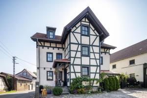 a white and black house with a dog in front of it at Dachwohnung Im Landhausstil in Meiningen