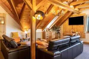 a living room with a leather couch and a tv at Dachwohnung Im Landhausstil in Meiningen