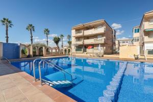 a large swimming pool with a building in the background at Casa Pepe in Los Narejos