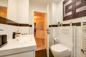 a bathroom with a white toilet and a sink at Ferienwohnung Bettersleepat8 in Limburg an der Lahn +28 photos