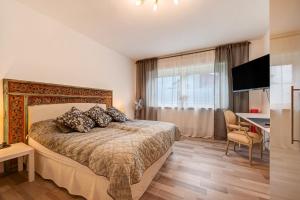 a bedroom with a bed and a desk and a television at Ferienwohnung Bettersleepat8 in Limburg an der Lahn