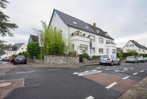 a white house with cars parked in a parking lot at Ferienwohnung Bettersleepat8 in Limburg an der Lahn