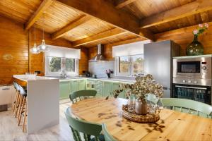 a kitchen with a wooden table and green cabinets at Cortijo la Jimena 2 in Benablón