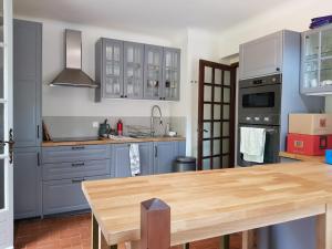 a kitchen with blue cabinets and a wooden table at Rives du Tarn in Peyreleau
