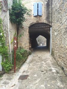 an alley in a brick building with a window at Rives du Tarn in Peyreleau +2 photos