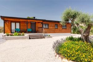 a log cabin with a tree and flowers in front of it at Cortijo la Jimena 2 in Benablón