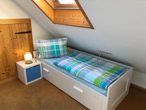 a small bedroom with a bed with a night stand at Faißbauernhof in Winden im Elztal