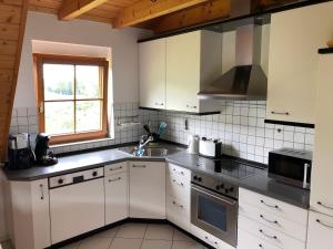 a kitchen with white cabinets and a sink at Faißbauernhof in Winden im Elztal