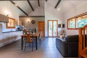 a kitchen and living room with a table and a couch at Chalet Sambuy - Val de Tamié in Faverges