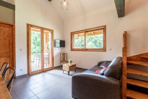 a living room with a couch and a television at Chalet Sambuy - Val de Tamié in Faverges