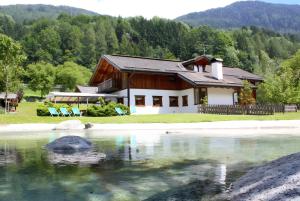a house sitting next to a body of water at Agriturismo Chalet Casa Al Campo in Giustino