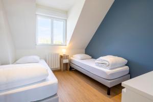 two beds in a small room with a window at Résidence des Saules in La Forêt-Fouesnant +58 photos