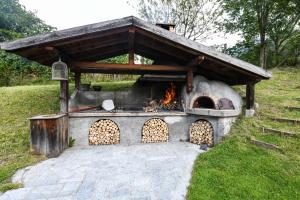 a stone oven with a fire inside of it at Agriturismo Chalet Casa Al Campo in Giustino