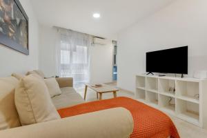 a white living room with a couch and a television at Apartamento Centro con Aparcamiento in Santa Cruz de Tenerife