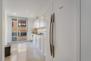 a kitchen with white cabinets and a refrigerator at Apartamento Centro con Aparcamiento in Santa Cruz de Tenerife
