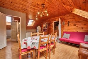 a dining room with a table and a purple couch at Gite des Granges in Tréminis