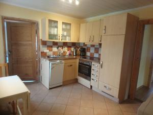 a kitchen with a white refrigerator and a stove at Naturteich-Haus in Kalkhorst
