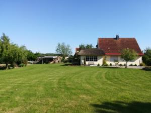 a house with a large green field in front of it at Naturteich-Haus in Kalkhorst