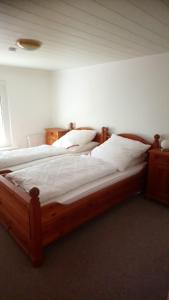 a bedroom with two beds with white sheets at Naturteich-Haus in Kalkhorst