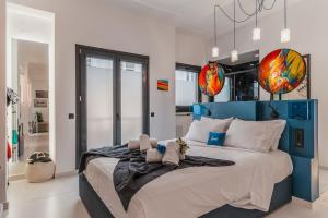 a bedroom with a large bed with a blue headboard at Artrock Experience Loft Gallery in Ermoupoli +61 photos