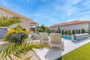 a backyard with chairs and a swimming pool at Villa du Lac - Gastes in Gastes