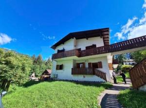 a large white house with a wooden balcony at Casa Fiocco di Neve in Vigo di Cadore