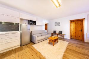 a kitchen and living room with a couch and a refrigerator at Casa Fiocco di Neve in Vigo di Cadore
