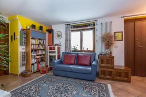 a living room with a blue chair with two red pillows at Chambre d'hôtes dans les Alpes in Conclonaz