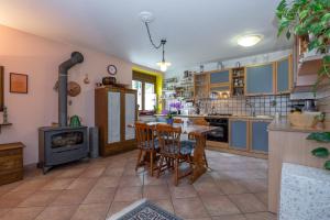 a kitchen with a table and a wood stove at Chambre d'hôtes dans les Alpes in Conclonaz