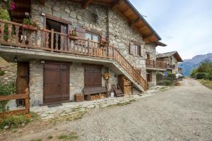 a stone building with wooden doors and a balcony at Chambre d'hôtes dans les Alpes in Conclonaz