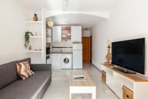 a living room with a couch and a flat screen tv at Moreras in Puerto de Mazarrón