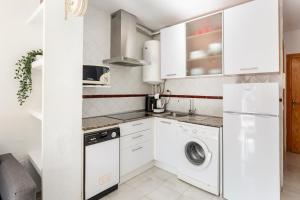 a white kitchen with a washer and dryer at Moreras in Puerto de Mazarrón