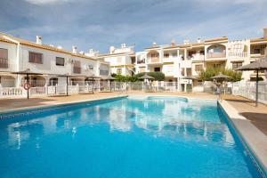 a large blue swimming pool in front of some apartments at Moreras in Puerto de Mazarrón