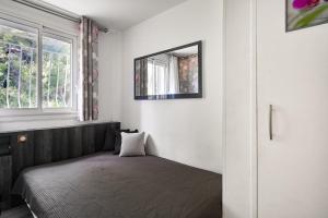 a bedroom with a bed and a mirror on the wall at T2 Le Panorama in Cassis