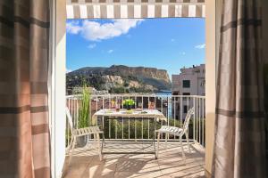 a balcony with a table with a view of a mountain at T2 Le Panorama in Cassis