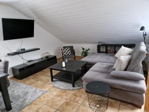 a living room with a couch and a tv at Ferienwohnung Arnsberger Wald in Möhnesee