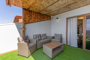 a patio with wicker chairs and a table at Terra Nova Penthouse in Lajita