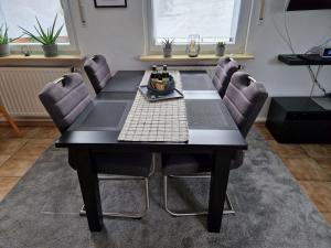 a black dining room table with chairs around it at Ferienwohnung Arnsberger Wald in Möhnesee +15 photos