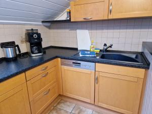 a kitchen with wooden cabinets and a sink at Ferienwohnung Arnsberger Wald in Möhnesee