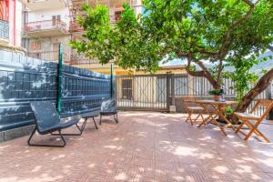 a patio with chairs and a table and a tree at La Casa dei Limoni in Gaggi