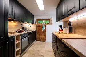 a kitchen with black cabinets and a wooden counter top at Gite Au pied du Pic du Midi in Campan