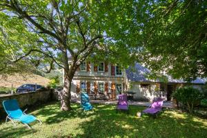 a group of chairs sitting in the grass in front of a house at Gite Au pied du Pic du Midi in Campan